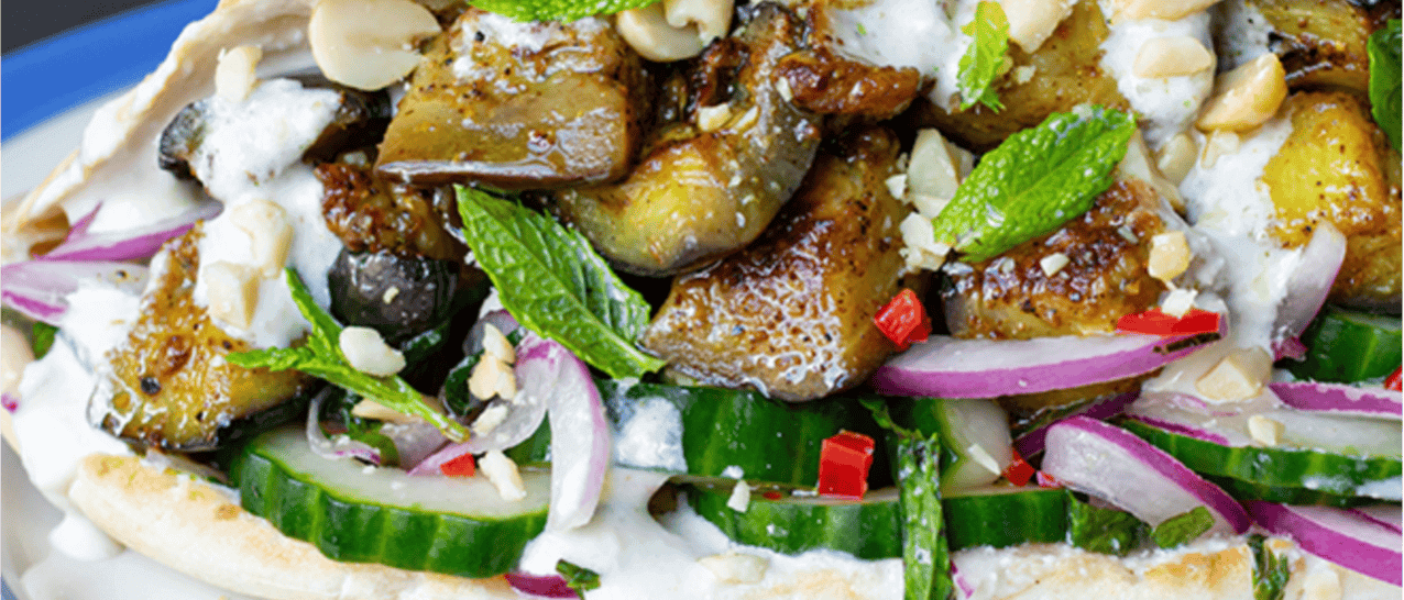 Cooked aubergine in a pitta with cucumber, yoghurt and other salad.